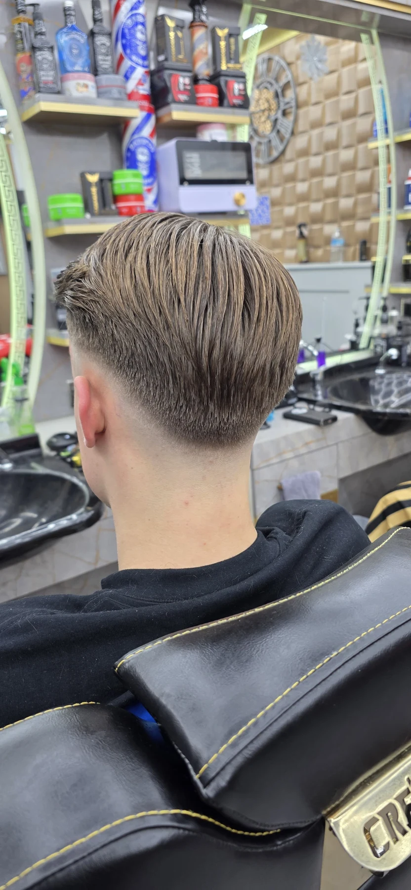 Back view of a combed-back haircut with a tapered neckline