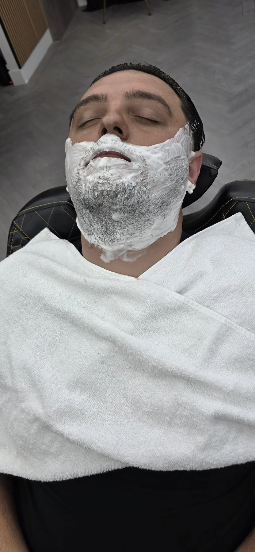 Customer reclining with shaving cream on his face