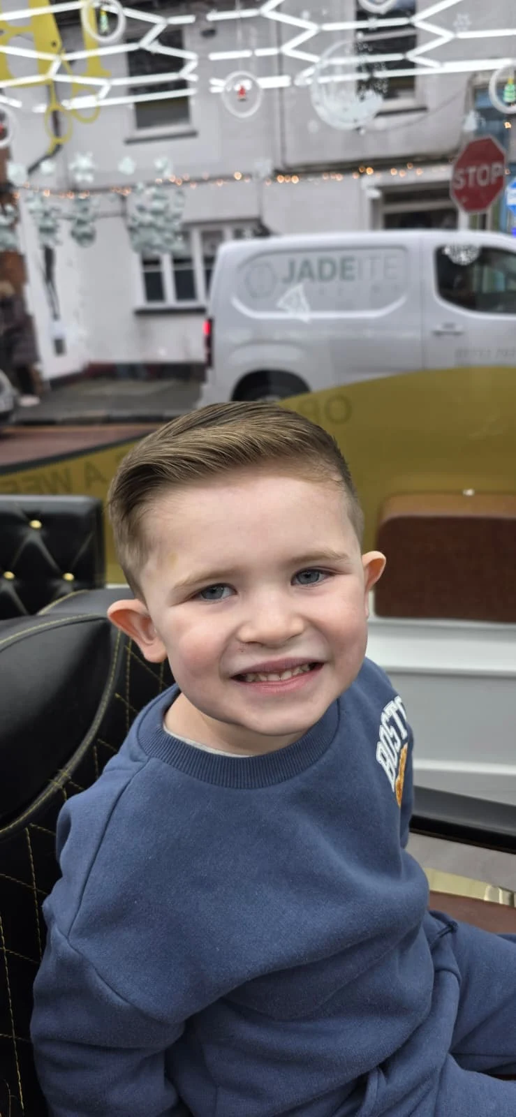 Smiling child after a haircut in the barber chair