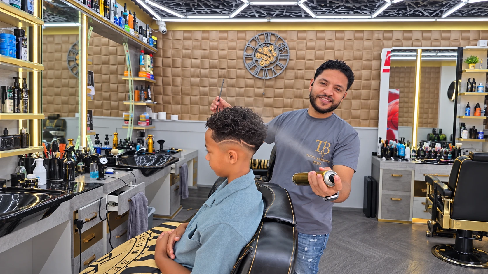 Barber finishing a curly top haircut with a clean fade